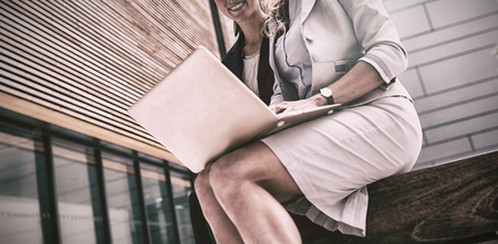 Businesswomen sitting and using laptop in office premisesの写真素材