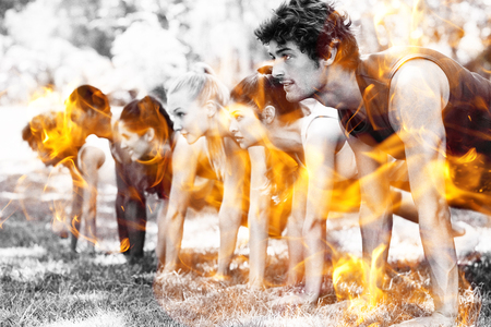 Fire flames against group of fitness people doing push ups in park
