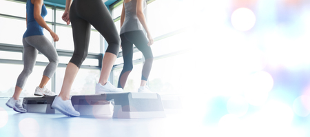 Three women doing aerobics against glowing background
