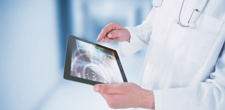 Doctor using digital tablet against dental equipmentの写真素材