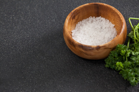 Close-up of bowl of sea salt against black backgroundの写真素材
