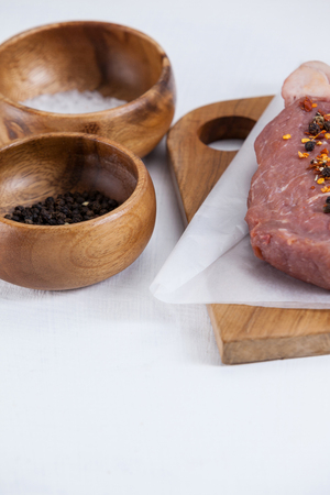 Sirloin chop, salt and black pepper against white backgroundの写真素材