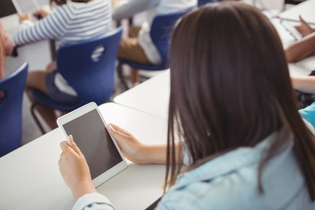 Student using digital tablet in classroom at schoolの写真素材