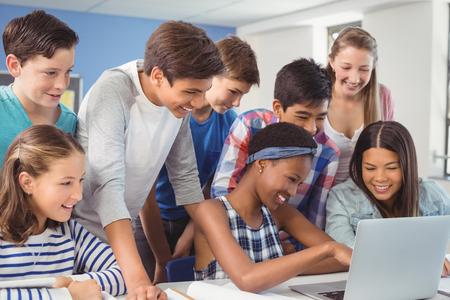 Group of students using laptop in classroom at schoolの写真素材