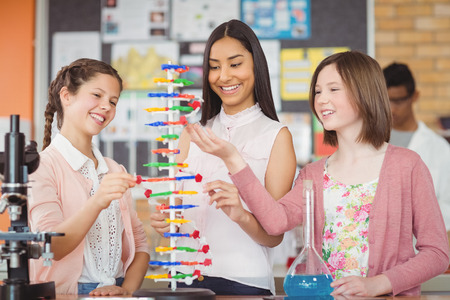 Students experimenting molecule model in laboratory at school
