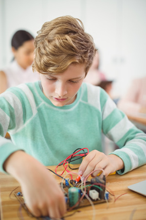 Schoolboy working on electronic project in classroom at schoolの写真素材