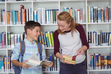 Happy students reading books in library at school