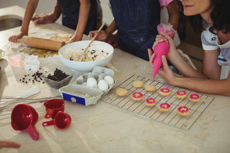 Mother and kids preparing cookies in kitchen at homeの写真素材