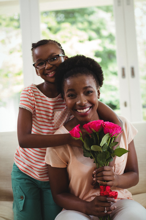 Portrait of daughter with arms around mother shouldersの写真素材