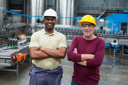 Portrait of two factory workers standing with their arms crossed in drinks production plantの写真素材