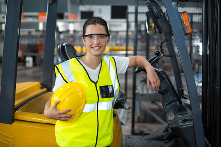 Portrait of smiling female worker standing in factoryの写真素材