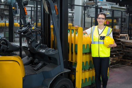 Portrait of smiling female worker standing in factoryの写真素材