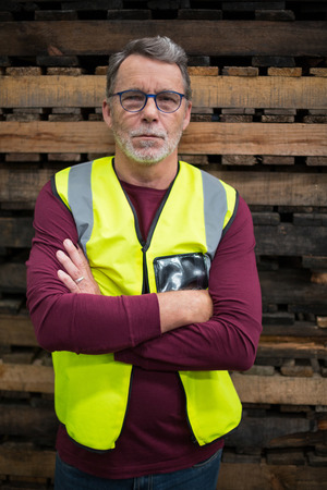 Portrait of male factory worker standing with arms crossed in drinks production factoryの写真素材