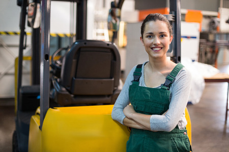 Portrait of female factory worker standing with arms crossed at drinks production factoryの写真素材