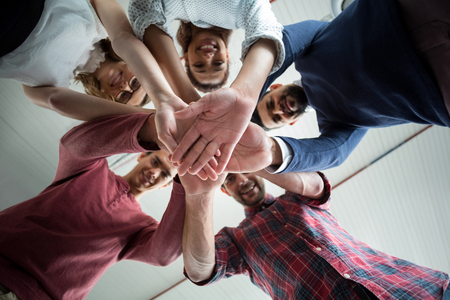Team of businesspeople forming hand stack in officeの写真素材