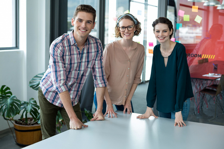 Portrait of smiling business executives standing together in officeの写真素材