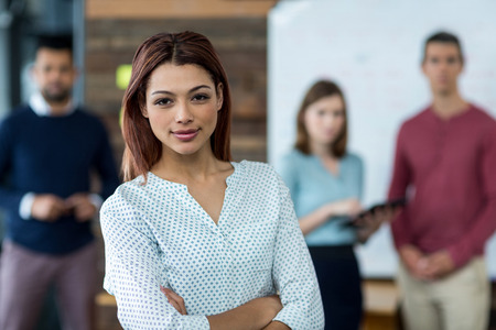 Portrait of business executive standing with arms crossed in office