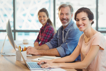 Team of graphic designers working together at desk in office