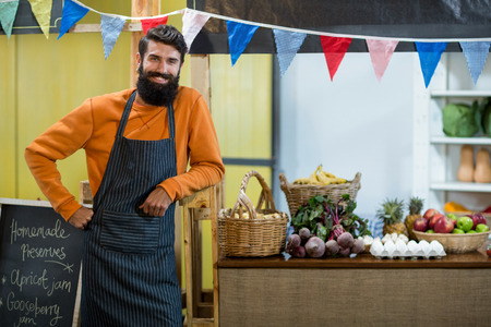 Portrait of a vendor standing at the counter in grocery storeの写真素材