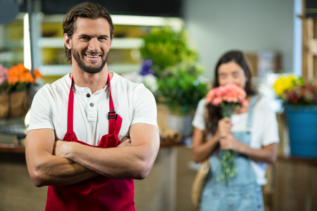 Portrait of a smiling florist standing in florist shop with arms crossedの写真素材