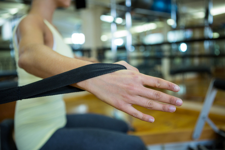 Woman practicing stretching exercise on reformer in gymの写真素材