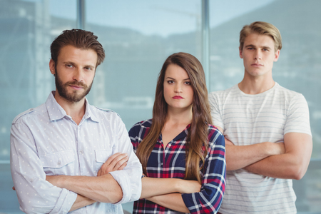 Portrait of executives standing with arms crossed in officeの写真素材