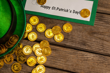 St Patricks Day leprechaun hat with gold chocolate coinsÂ on wooden background