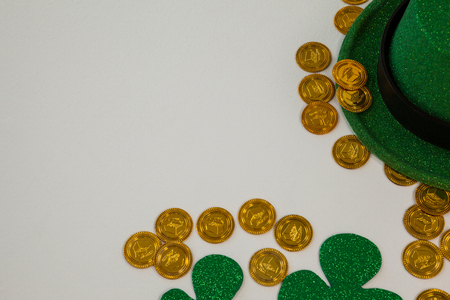 St. Patricks Day leprechaun hat, shamrocks and chocolate gold coins on white backgroundの写真素材