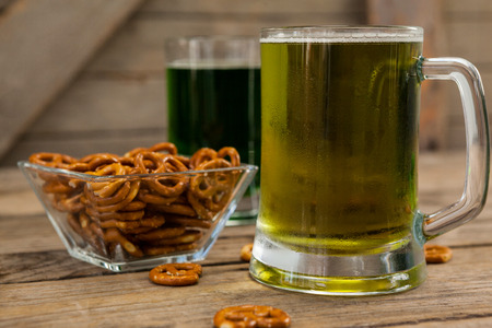 St Patricks Day two mugs of beer with pretzel on wooden surfaceの写真素材