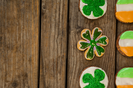 St. Patricks Day cookies decorated with irish flag and shamrock toppings on wooden backgroundの写真素材