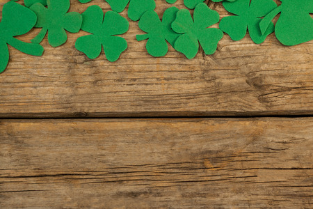 St. Patricks Day shamrock, beer bottle and pot filled with chocolate gold coins on wooden tableの写真素材