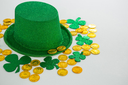 St. Patricks Day leprechaun hat, shamrocks and chocolate gold coins on white backgroundの写真素材