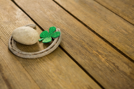 St Patricks Day shamrocks with horseshoe and pebble on wooden surfaceの写真素材