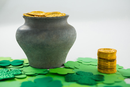 St. Patricks Day shamrock and pot filled with chocolate gold coins on white backgroundの写真素材