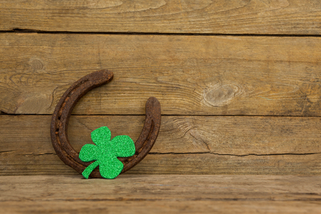 St Patricks Day shamrock with horseshoe on wooden surfaceの写真素材