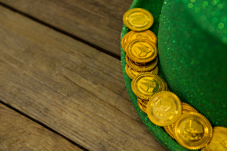 St Patricks Day leprechaun hat with gold chocolate gold coinsÂ on wooden backgroundの写真素材