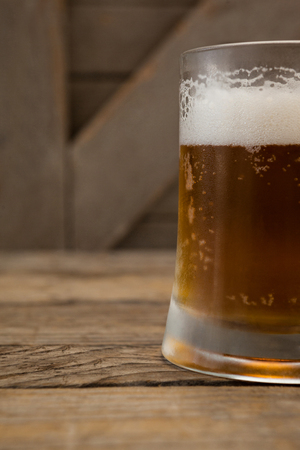 Close-up of mug of beer on wooden tableの写真素材