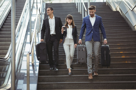 Smiling business executives walking on stairs outside platformの写真素材