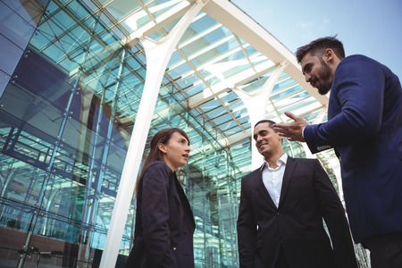 Smiling business executives interacting with each other outside platformの写真素材