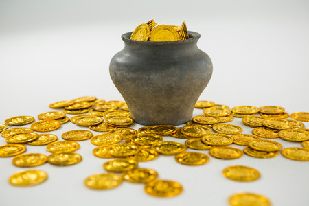 St. Patricks Day pot filled with chocolate gold coins on white backgroundの写真素材