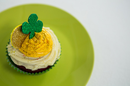 St Patricks Day shamrock on the cupcake kept in plate on white backgroundの写真素材