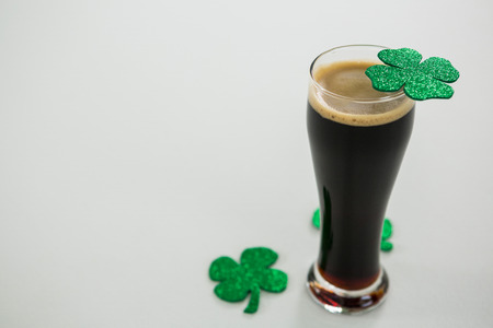 St Patricks Day glass of beer with shamrock on white backgroundの写真素材