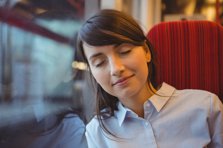 Businesswoman sleeping while travelling in trainの写真素材