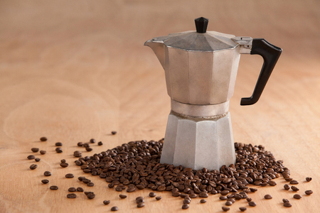 Metallic coffee maker with coffee beans on wooden backgroundの写真素材