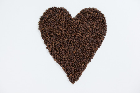 Coffee beans forming heart shaped on white backgroundの写真素材