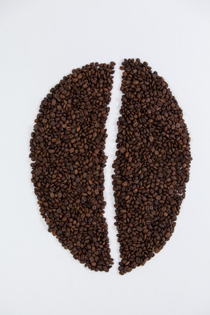 Coffee beans forming coffee bean shape on white backgroundの写真素材