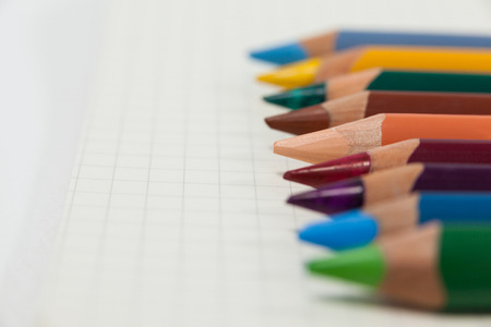 Close-up of colored pencils arranged in a row on white backgroundの写真素材