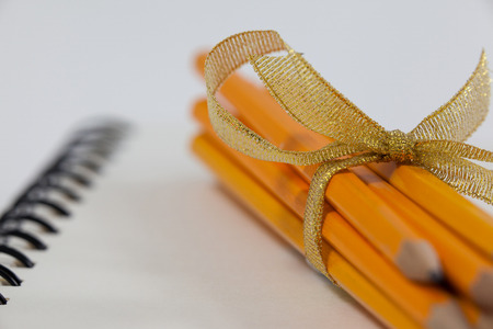 Bunch of pencils wrapped with ribbons on bookの写真素材