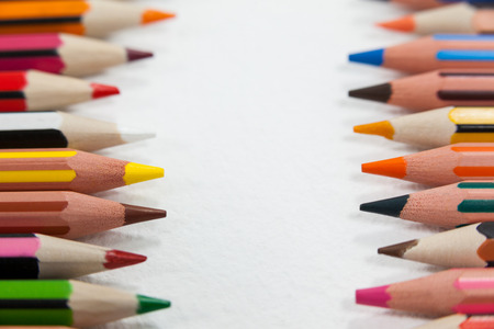 Close-up of colored pencils arranged in a row on white backgroundの写真素材