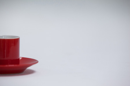 Close-up red coffee cup and saucer on white backgroundの写真素材